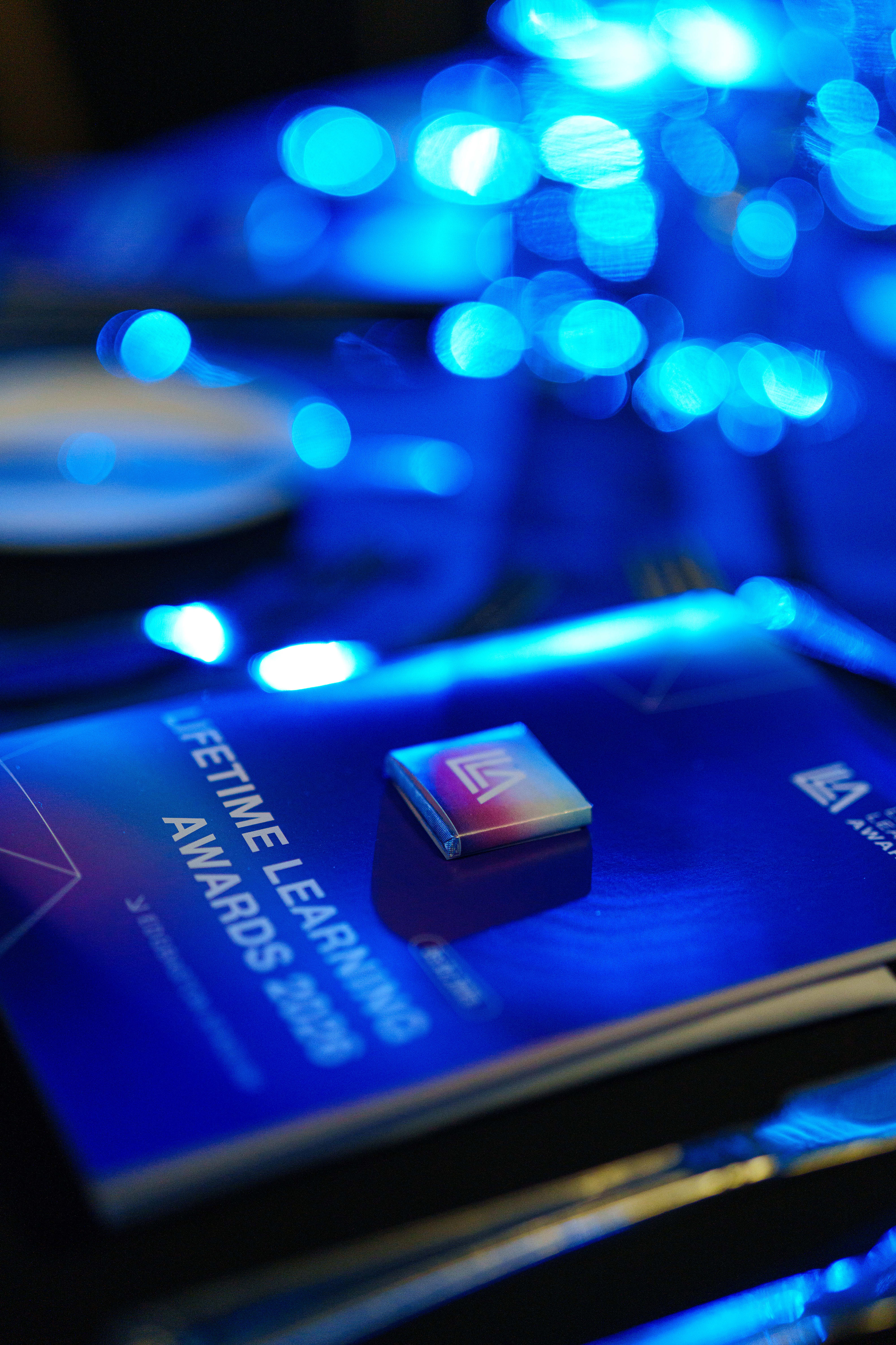 Lifetime Learning Awards 2026 — printed programme and branded badge